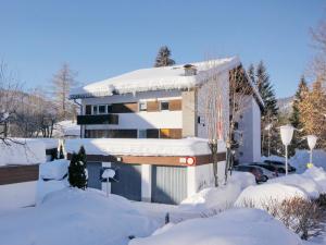 een huis is bedekt met sneeuw met een oprit bij Apartment Am Birkenhain-1 by Interhome in Seefeld in Tirol