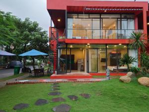 a red house with a garden and a patio at Seaside Villas An Vien Nha Trang in Nha Trang