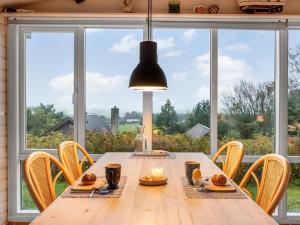 uma sala de jantar com uma mesa de madeira e uma grande janela em Holiday Home Dimo - 300m to the inlet in The Liim Fiord by Interhome em Struer