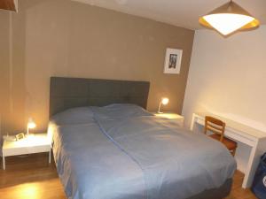 een slaapkamer met een bed en 2 tafels met lampen bij Apartment Maze B by Interhome in Chermignon-dʼen Haut