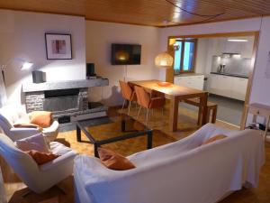 een woonkamer met witte meubels en een open haard bij Apartment Maze B by Interhome in Chermignon-dʼen Haut