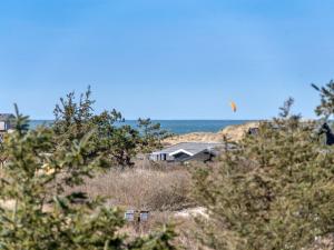 a kite flying in the sky over a house at Holiday Home Annrike - 400m from the sea in NW Jutland by Interhome in Saltum