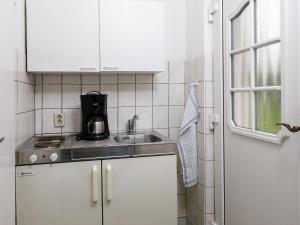 Una cocina con gabinetes blancos y un fregadero. en Holiday Home Bungalow Nr-4 by Interhome, en Zinnowitz