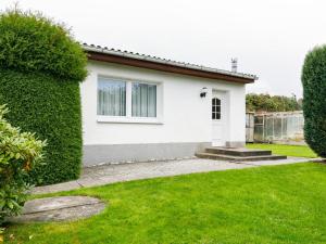 una casa blanca con un seto verde en Holiday Home Bungalow Nr-4 by Interhome, en Zinnowitz