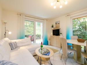 a living room with a white couch and a table at Apartment Meerzeit by Interhome in Trassenheide +23 photos
