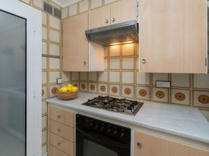 uma cozinha com um fogão e uma taça de fruta em Apartment Calima by Interhome em Sant Antoni de Calonge