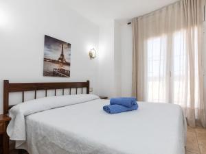 um quarto com uma cama com uma almofada azul em Apartment Calima by Interhome em Sant Antoni de Calonge
