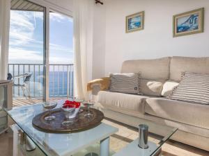 uma sala de estar com um sofá e uma mesa com copos de vinho em Apartment Calima by Interhome em Sant Antoni de Calonge