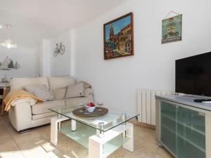 uma sala de estar com um sofá e uma televisão em Apartment Calima by Interhome em Sant Antoni de Calonge