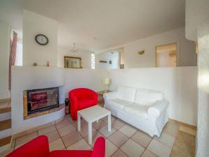 a living room with a white couch and a red chair at Holiday Home Bonita by Interhome in Cala Anguila