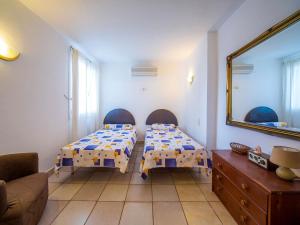 Pokój z 2 łóżkami, lustrem i kanapą w obiekcie Holiday Home Bonita by Interhome w mieście Cala Anguila