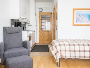 ein Wohnzimmer mit einem Stuhl und einem Bett in der Unterkunft Holiday Home Rautulampi h22 by Interhome in Saariselkä