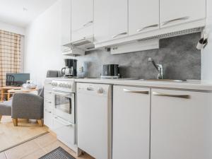eine Küche mit weißen Schränken und einem Waschbecken in der Unterkunft Holiday Home Rautulampi h22 by Interhome in Saariselkä
