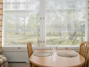 ein Esszimmer mit einem Tisch und 2 Fenstern in der Unterkunft Holiday Home Rautulampi h22 by Interhome in Saariselkä