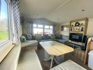 a living room with a couch and a table at Spacious Caravan On The Suffolk Coast With Outside Decking Too Ref 20044bs in Hopton on Sea