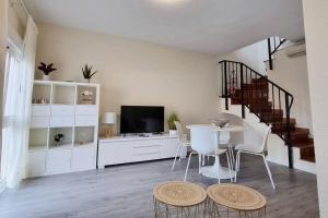 ein Wohnzimmer mit Tisch und Stühlen und einer Treppe in der Unterkunft Casa Ophélia - Albir in Albir