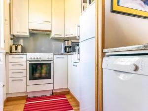 - une cuisine avec des appareils blancs et un tapis rouge dans l'établissement Holiday Home Soidinaukia a 3 by Interhome, à Saariselka