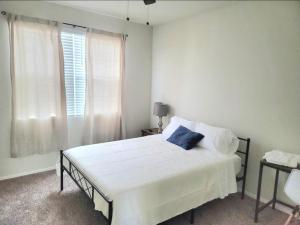 una camera da letto con un letto bianco con un cuscino blu di Phoenix comfort home BNB a Phoenix