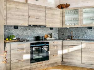 a kitchen with wooden cabinets and an oven at Holiday Home Kontiokota by Interhome in Saariselka +18 photos