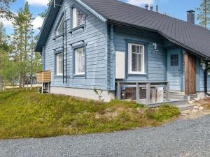 a blue house with a porch on a hill at Holiday Home Velho 2 by Interhome in Saariselka