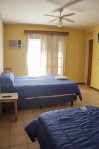 聖胡安的住宿－Hotel cuesta del viento II，一间卧室配有两张床和吊扇