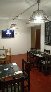 une salle à manger avec des tables et des chaises et une télévision à écran plat dans l'établissement Hotel cuesta del viento II, à San Juan