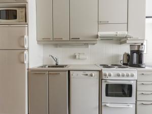 a kitchen with white cabinets and a sink at Holiday Home Rautulampi h 23 by Interhome in Saariselka +2 photos