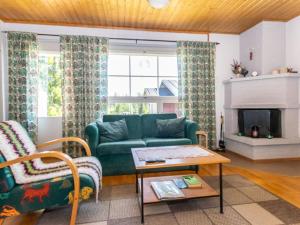 a living room with a green couch and a fireplace at Holiday Home Urupää c 13 by Interhome in Saariselka