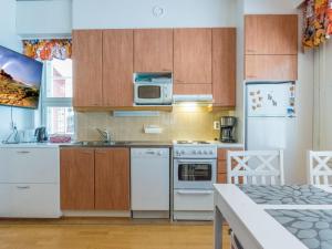 una cocina con electrodomésticos blancos y armarios de madera en Holiday Home Rautulampi h 24 by Interhome, en Saariselkä