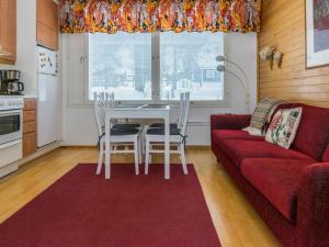 sala de estar con sofá rojo, mesa y sillas en Holiday Home Rautulampi h 24 by Interhome, en Saariselkä