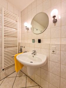 a bathroom with a sink and a mirror at Störtebeker Residenz in Greetsiel