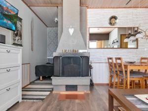 a living room with a fireplace and a dining room at Holiday Home Siularinne b 8 by Interhome in Saariselka