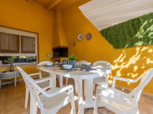 una sala da pranzo con tavolo e sedie bianchi di Holiday Home Ernestina by Interhome a Riumar