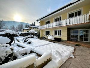 a yard covered in snow in front of a house at Luxury-Suites Traunsee in Traunkirchen