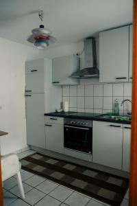 a kitchen with white cabinets and a stove top oven at Ostertor 2 in Sarstedt