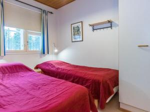 - 2 lits dans une chambre avec des draps rouges dans l'établissement Holiday Home Urupää d 17 by Interhome, à Saariselka