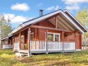 a log cabin with a porch and white fence at Holiday Home Puuhapirtti 1 by Interhome in Sirkka