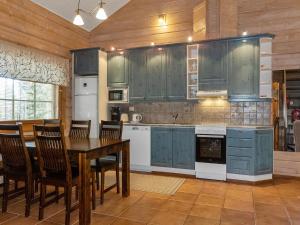 a kitchen with blue cabinets and a table and chairs at Holiday Home Puuhapirtti 1 by Interhome in Sirkka