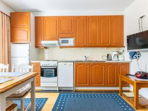 a kitchen with wooden cabinets and white appliances at Holiday Home Outapailakka j 10 by Interhome in Saariselka