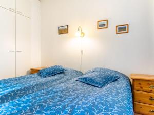 a bedroom with a blue bed with two pillows at Holiday Home Outapailakka j 10 by Interhome in Saariselka +6 photos