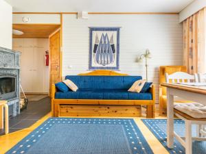 a living room with a blue couch and a fireplace at Holiday Home Outapailakka j 10 by Interhome in Saariselka