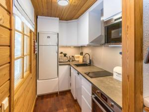 a kitchen with white cabinets and a refrigerator at Holiday Home Saaga by Interhome in Saariselka