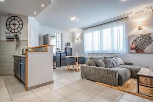 a living room with a couch and a kitchen at L'Evasion - Sauna Jacuzzi Cinema in Tours