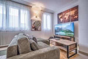 a living room with a couch and a tv at L'Evasion - Sauna Jacuzzi Cinema in Tours