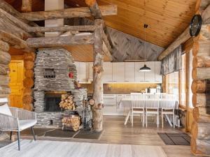 a kitchen and dining room with a stone fireplace at Holiday Home Sallanhelmi b1 by Interhome in Salla