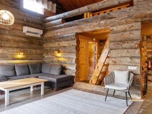 a living room with a couch and a table in a log cabin at Holiday Home Sallanhelmi b1 by Interhome in Salla