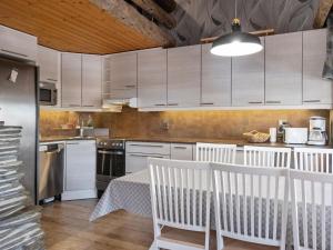 a kitchen with white cabinets and a table and chairs at Holiday Home Sallanhelmi b1 by Interhome in Salla +12 photos