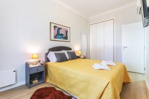 een slaapkamer met een bed met een gele sprei bij Vita Portucale ! Moscavide Casa Branca w/ Terrace in Lissabon