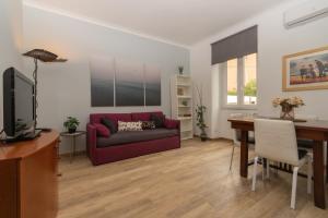 sala de estar con sofá rojo y escritorio en [ROME 15min]Modern Accommodation, Airport,Station,LinkHouseCiampino en Ciampino
