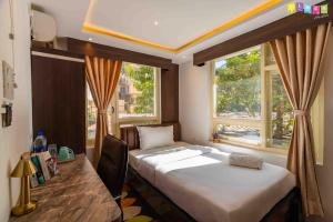 1 dormitorio con cama, escritorio y ventana en Flock Hostel Kathmandu, en Katmandú